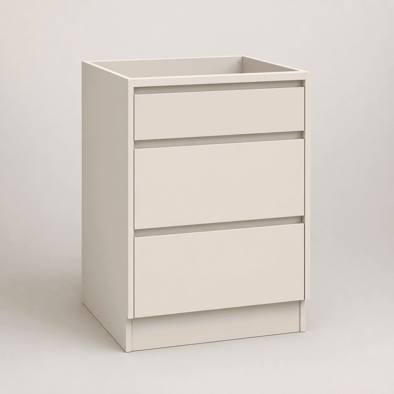 Three-drawer base cabinet — studio view, warm beige finish with matte black pulls